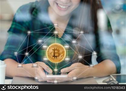 Closeup Asian businesswoman hand using the smart mobile phone with Bitcoins mockup and Distributed computer network hologram in workplace co-working space,blockchain and bitcoin concept
