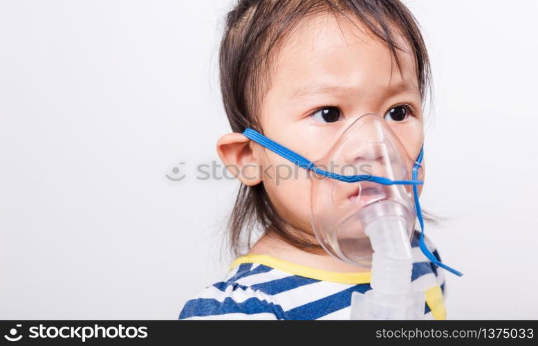 Closeup Asian face, Little baby girl sick her using steam inhaler nebulizer mask inhalation oneself on white background with copy space, health medical care