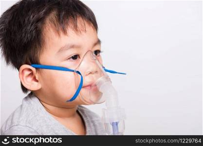 Closeup Asian face, Little children boy sick he using steam inhaler nebulizer mask inhalation oneself on white background, health medical care