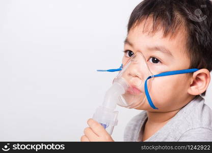 Closeup Asian face, Little children boy sick he using steam inhaler nebulizer mask inhalation oneself on white background, health medical care