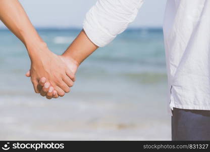 Closeup asian gay couple holding hands together on the beach with relax and leisure in summer, LGBT homosexual legal two man happy and romantic in vacation, relationship sex lover concept.