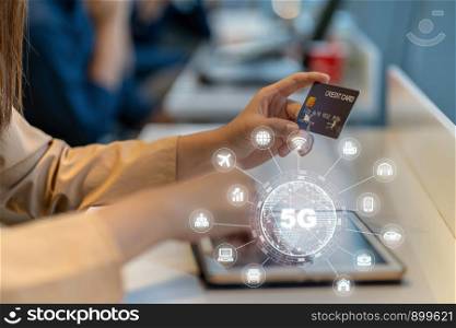 Closeup Asian woman using credit card by tablet for 5G technology with various icon internet of thing in department store, IOT and cashless concept, credit card mockup