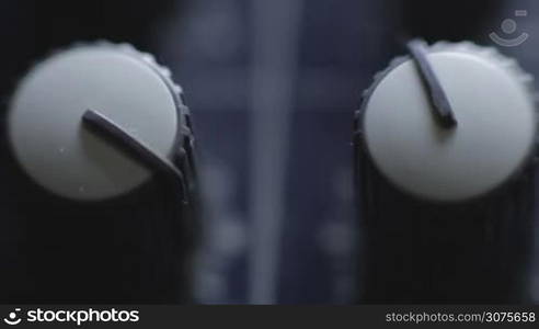 Closeup audio mixer knobs on mixer console and then shallow depth of field of mixer desk