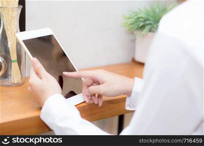 Closeup beautiful asian businesswoman holding tablet, woman hand touch screen using digital tablet computer and working internet online coffee shop, communication concept.