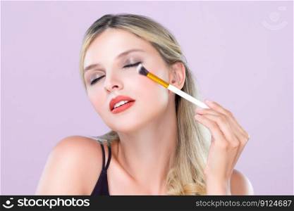 Closeup beautiful girl with flawless applying alluring eye shadow makeup with eyeliner brush. Cosmetic facial painting process on lovely young woman with perfect clean skin on pink isolated background. Closeup beautiful girl with flawless applying alluring eye shadow makeup.