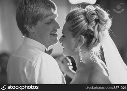 Closeup black and white portrait of bride and groom having first dance
