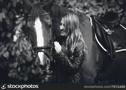 Closeup black and white portrait of smiling woman walking with horse