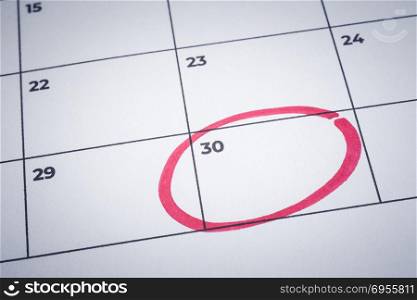 Closeup blank planner calendar, minimal style background. Focus on end of month with red circle mark. Important date notification, reminder note, business timetable schedule, project management.