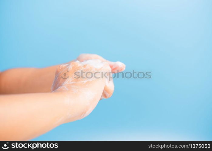 Closeup body care Asian young woman washing hands with soap have foam, hygiene prevention COVID-19 or coronavirus protection concept, isolated on blue background