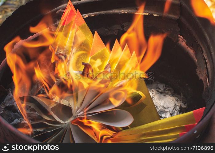 Closeup burning Joss paper or Hell Bank Note for ancestors in Chinese new year or Tomb Sweeping Day.