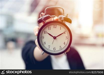 closeup business people hand holding alarm bell clock outdoor blur office city background
