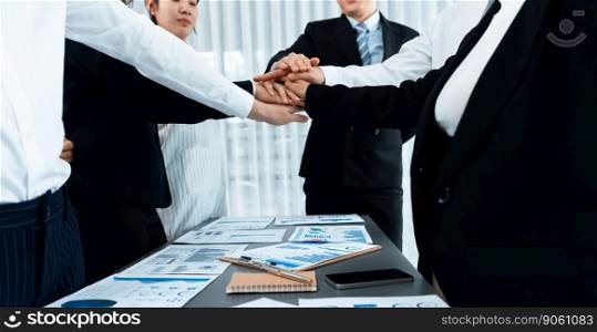 Closeup business team of suit-clad businessmen and women join hand stack together and form circle. Colleague collaborate and work together to promote harmony and teamwork concept in office workplace.. Closeup business team join hand stack together for harmony concept.