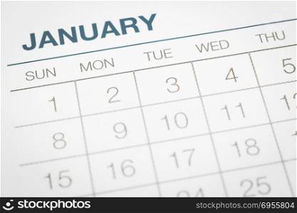 Closeup calendar page with days and dates in January month. Selective focus shown dot prints, blurred at edges, blue tone vintage minimal style. Appointment planning, business timetable management.
