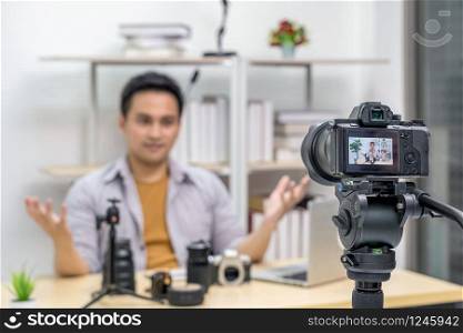 Closeup Camera taking video and live with laptop of Asian Vlogger man satisfied the camera lens each media, sharing knowledge to audience via camera by social media channel,vlog and Influencer concept