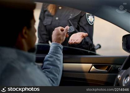 Closeup car driver giving key to policewoman. Consequences od auto accident or exceeding speed limit. Closeup car driver giving key to policewoman