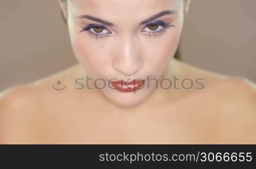 Closeup clip of a beautiful brunette womans face with lovely brown eyes and smooth complexion