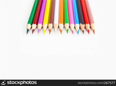 Closeup color drawing supplies, colorful crayon pencils assortment on white background with copy space. For banner, design. Top view.