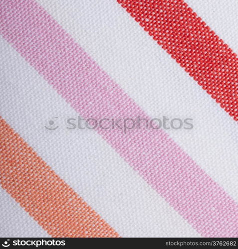 Closeup colorful red pink orange diagonal striped fabric textile as background texture or pattern. Macro.