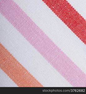 Closeup colorful red pink orange diagonal striped fabric textile as background texture or pattern. Macro.