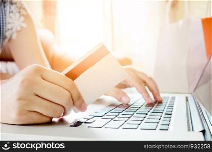 Closeup credit card ,Woman shopping online using laptop with credit card enjoying in home