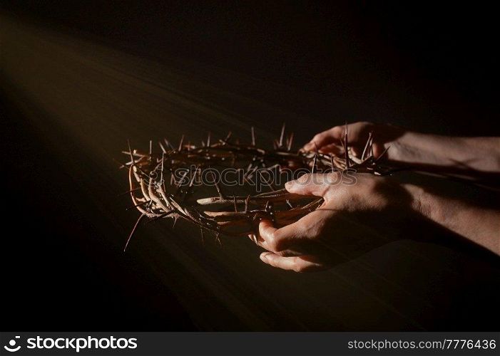 Closeup Crown of thorns in hands and sun rays