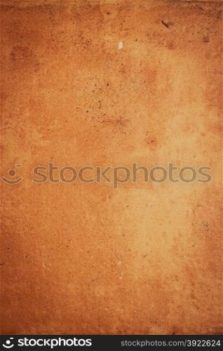 Closeup detail of a ocher stone wall background.