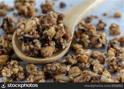Closeup detail of homemade healthy and nutritious breakfast granola in a wooden spoon on kitchen table in fresh morning sunlight.. Closeup detail of homemade healthy and nutritious breakfast granola in a wooden spoon on kitchen table in fresh morning sunlight