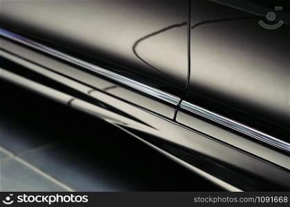 Closeup door of a modern luxury black car with beautiful reflections. Exterior details