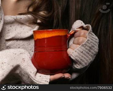 Closeup female hands holding a nice red cup of hot drink