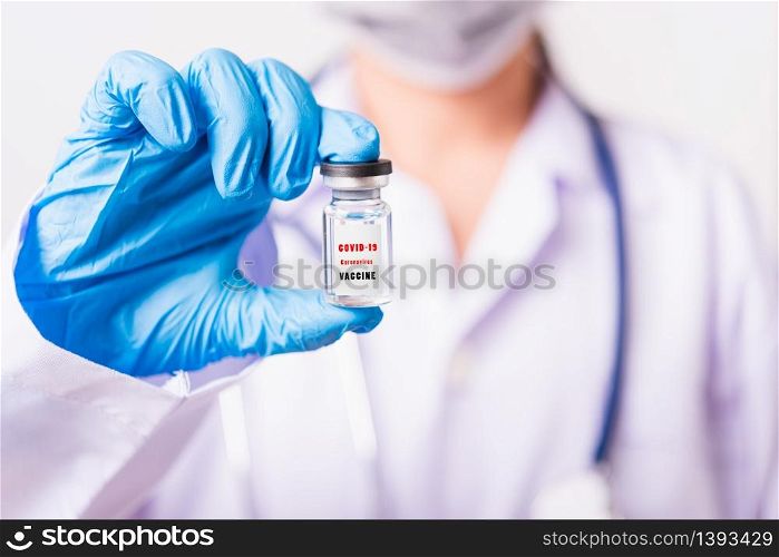 "Closeup female woman doctor or scientist in uniform wearing face mask protective in lab use hand finger hold vial vaccine bottle, and on vial vaccine have "CORONAVIRUS VACCINE" text label, COVID-19"