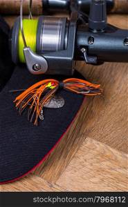 closeup fishing bait and reel with line on wooden background