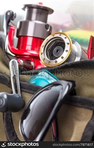 closeup fishing tackles and lures in open handbag. for design advertising or publication