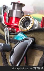 closeup fishing tackles and lures in open handbag. for design advertising or publication