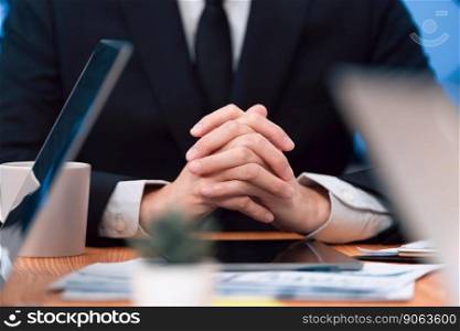 Closeup focus boss body language executive, CEO sitting confidently at meeting table or desk in professional harmony office workplace with hand clasped together, thinking and making business decision.. Closeup focus boss sitting at the meeting table as harmony concept in workplace.