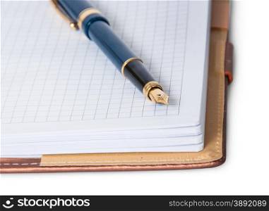 Closeup fountain pen on top of the open notebook isolated on white background