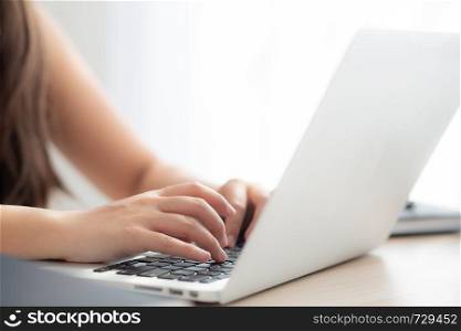 Closeup freelance asian woman working and typing on laptop computer at desk office with professional, girl using notebook checking email or social network, business and lifestyle concept.
