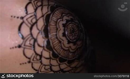 Closeup freshly done henna tattoo on woman&acute;s shoulder - video in slow motion