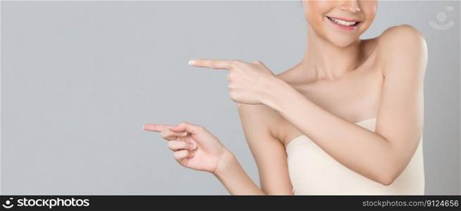 Closeup glamorous beautiful woman with perfect makeup clean skin pointing finger in copyspace isolated background. Promotion indicated by hand gesture concept for skincare product advertisement.. Closeup glamorous woman pointing finger advertising skincare product.