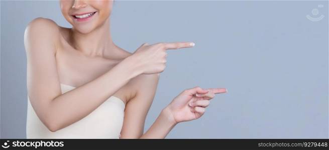 Closeup glamorous beautiful woman with perfect makeup clean skin pointing finger in copyspace isolated background. Promotion indicated by hand gesture concept for skincare product advertisement.. Closeup glamorous woman pointing finger advertising skincare product.