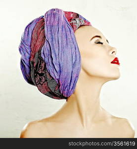 Closeup glamorous portrait of a young woman with decorative scarf on her head