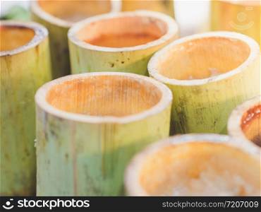 Closeup Glutinous sticky rice soaked in coconut milk and roasted baked in bamboo stem or Khao Lam, Thai style dessert.