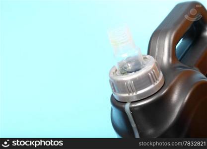 Closeup gray canister with car engine oil blue background