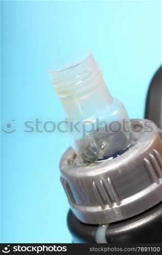 Closeup gray canister with car engine oil blue background