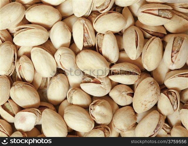 Closeup group of pistachios nuts in brown beige nutshells shells as food background. Diet and healthy nutrition.