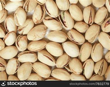 Closeup group of pistachios nuts in brown beige nutshells shells as food background. Diet and healthy nutrition.