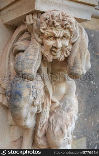 Closeup half naked faunus statue under column at Zwinger palace in Dresden, Germany&#xA;