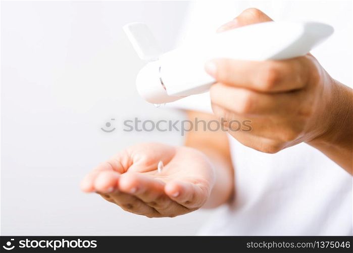 Closeup Hand Asian young woman applying drop dispenser sanitizer alcohol gel on hand wash cleaning, hygiene prevention COVID-19 or coronavirus protection concept, isolated on white background