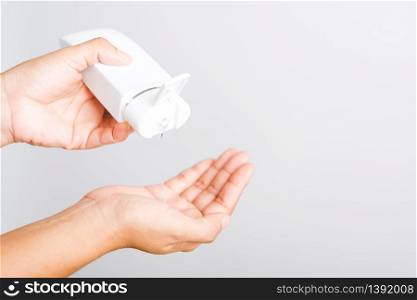 Closeup Hand Asian young woman applying drop dispenser sanitizer alcohol gel on hand wash cleaning, hygiene prevention COVID-19 or coronavirus protection concept, isolated on white background