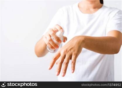 Closeup Hand Asian young woman applying spray pump dispenser sanitizer alcohol on back hand wash cleaning, hygiene prevention COVID-19 or coronavirus protection concept, isolated on white background