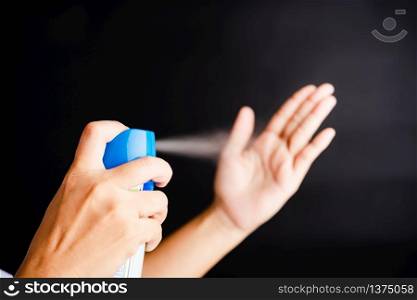 Closeup Hand Asian young woman applying spray pump dispenser sanitizer alcohol on hand wash cleaning, hygiene prevention COVID-19 or coronavirus protection concept, isolated on black background